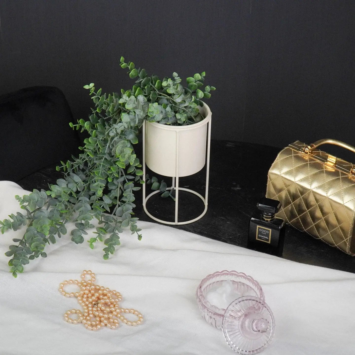 Plantenpot op voet. Beige. Zandkleurige bloempot van metaal.