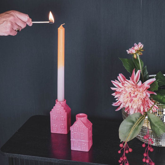 Felroze kandelaars in de vorm van Amsterdamse huisjes. 