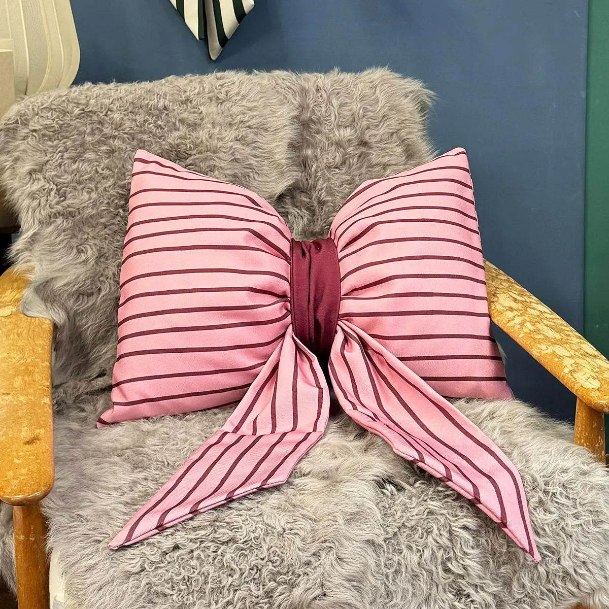 Kussen in de vorm van een strik. Roze met burgundy strepen 